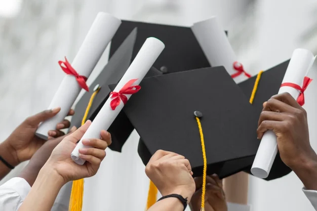 close-up-hands-holding-diplomas-caps-1.webp